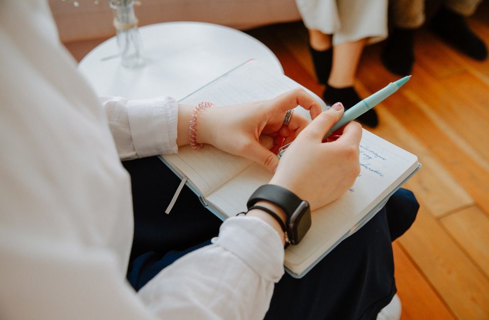 Psychedelic Assisted Therapy - therapist holding notebook during a therapy session