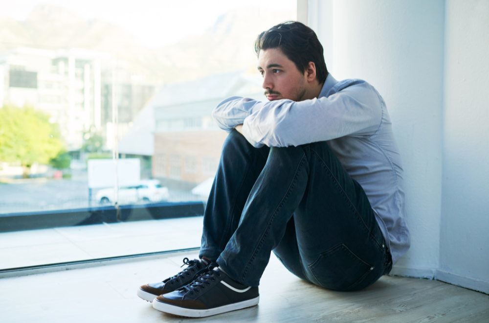 CPTSD - picture of a man sitting holding his knees against a wall