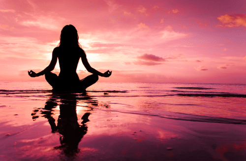 Woman practicing meditation on the beach